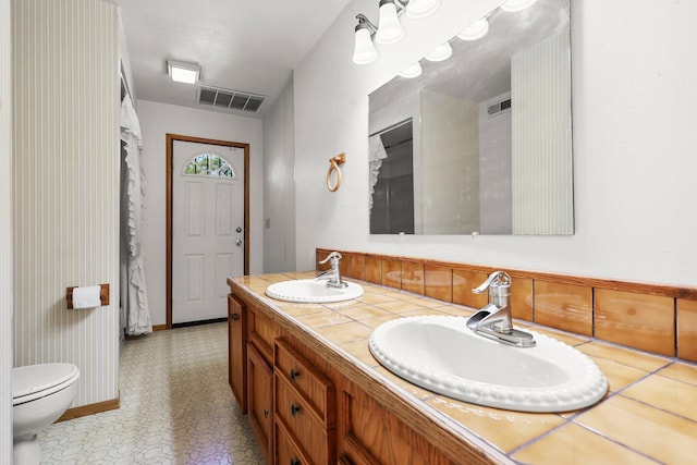 16588 Stanislaus Dr, Redding, CA 96001 - full bathroom with double vanity, visible vents, a sink, and toilet