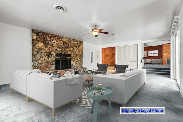 16588 Stanislaus Dr, Redding, CA 96001 - living area with ceiling fan, a fireplace, visible vents, carpet floors, and wooden walls