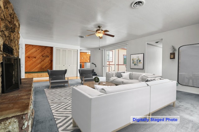 16588 Stanislaus Dr, Redding, CA 96001 - living room featuring a fireplace, carpet, a ceiling fan, visible vents, and wood walls