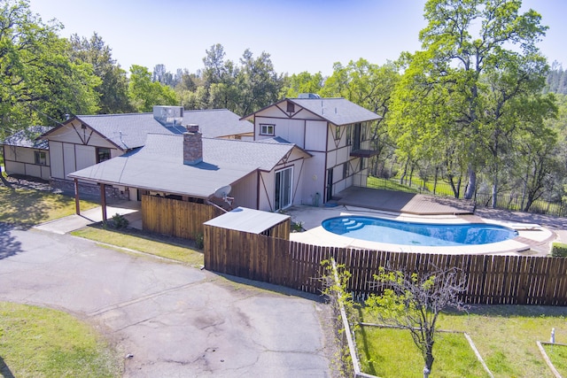 16588 Stanislaus Dr, Redding, CA 96001 - exterior space featuring a yard, a chimney, aphalt driveway, fence, and a fenced in pool