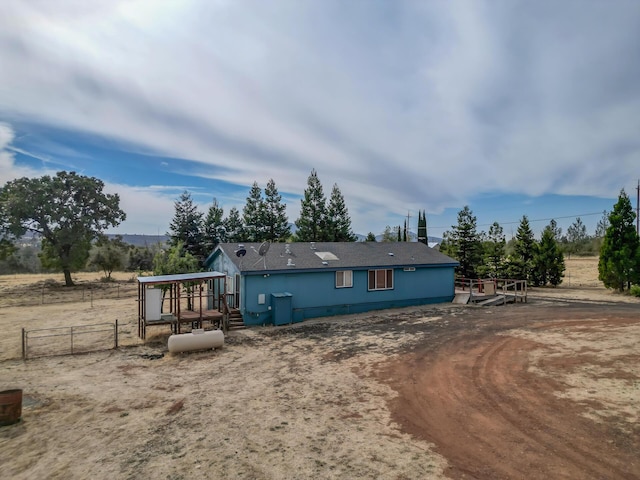 rear view of property featuring fence