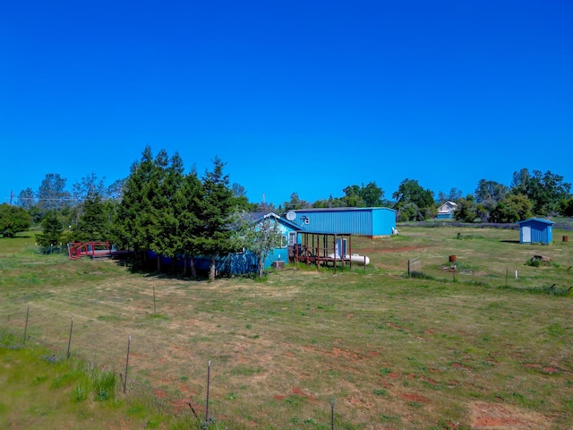 view of yard with an outbuilding, a storage shed, and fence