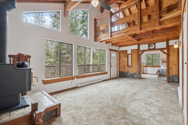 2120 Pack Trl, Mount Shasta, CA 96067 - unfurnished living room with high vaulted ceiling, a wood stove, plenty of natural light, and a baseboard heating unit