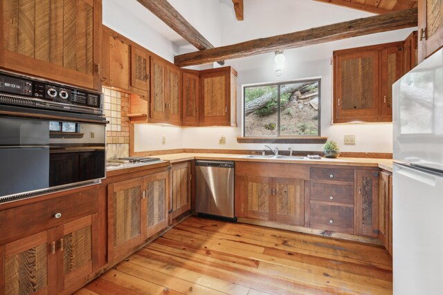 2120 Pack Trl, Mount Shasta, CA 96067 - kitchen featuring light wood-style floors, light countertops, stainless steel appliances, brown cabinets, and beam ceiling