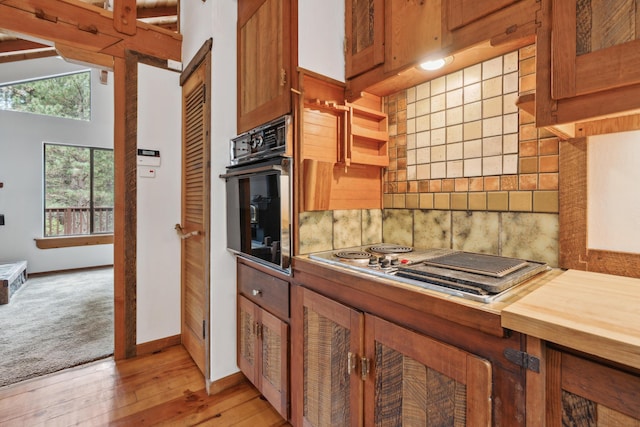 2120 Pack Trl, Mount Shasta, CA 96067 - kitchen with tasteful backsplash, black oven, light wood-style flooring, brown cabinetry, and stainless steel electric stovetop