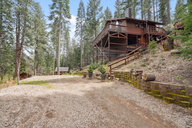 2120 Pack Trl, Mount Shasta, CA 96067 - view of home's exterior with an outdoor structure, a deck, driveway, and a chimney
