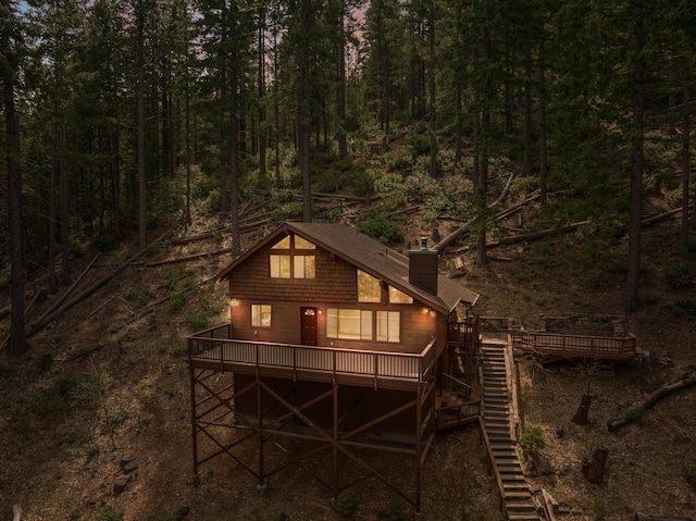 2120 Pack Trl, Mount Shasta, CA 96067 - rear view of house featuring a view of trees, a wooden deck, stairs, and a chimney