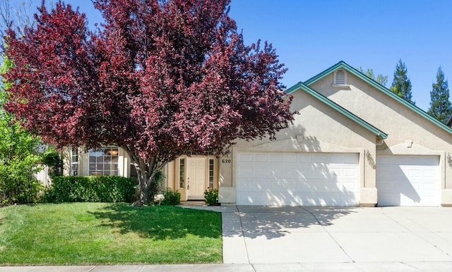 620 San Gabriel St, Redding, CA 96003 - view of front of home with a garage, stucco siding, concrete driveway, and a front lawn