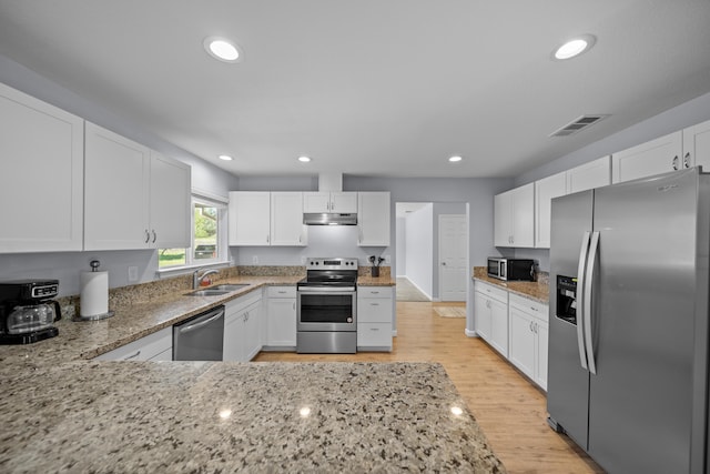 20035 Old Alturas Rd, Redding, CA 96003 - kitchen with under cabinet range hood, appliances with stainless steel finishes, a sink, and light stone counters