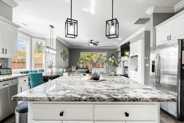 2796 Madison River Dr, Redding, CA 96002 - kitchen featuring visible vents, a ceiling fan, crown molding, light stone countertops, and stainless steel appliances