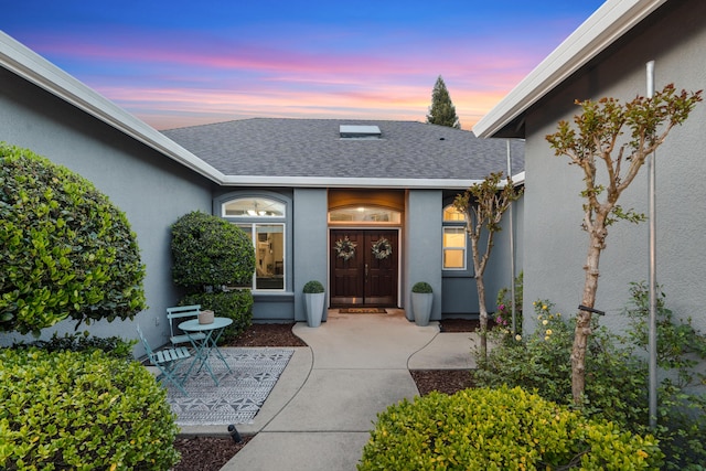 2796 Madison River Dr, Redding, CA 96002 - view of exterior entry with a patio, stucco siding, and a shingled roof