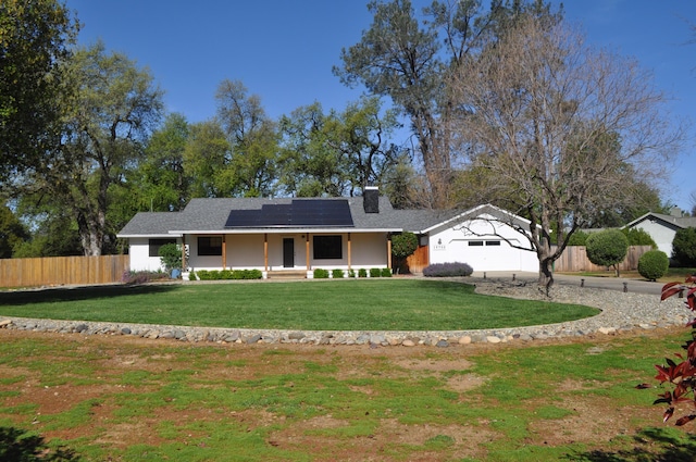 19702 Midland Dr, Redding, CA 96003 - view of front of home with a front yard, solar panels, covered porch, fence, and driveway
