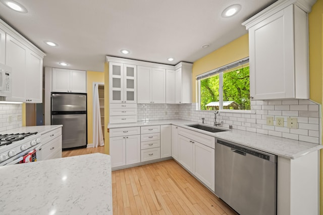 19702 Midland Dr, Redding, CA 96003 - kitchen featuring tasteful backsplash, light wood-type flooring, white cabinetry, stainless steel appliances, and a sink