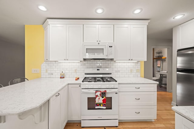19702 Midland Dr, Redding, CA 96003 - kitchen with a peninsula, white appliances, and white cabinets