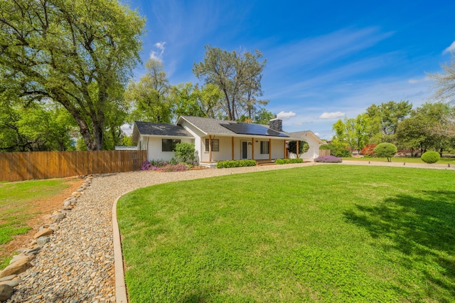 19702 Midland Dr, Redding, CA 96003 - single story home with roof mounted solar panels, stucco siding, fence, and a front lawn