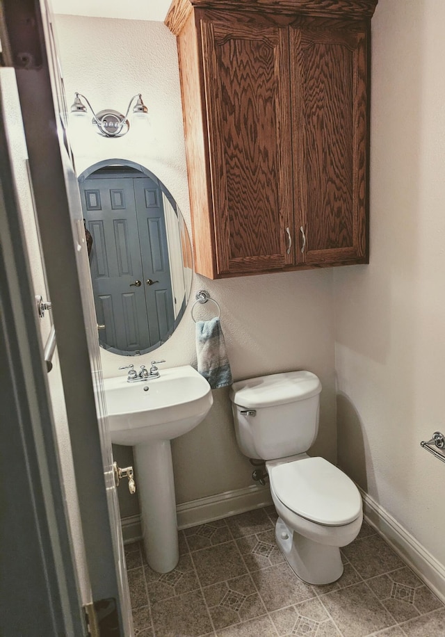 half bathroom featuring toilet and baseboards