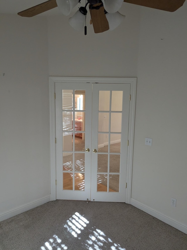 carpeted empty room with french doors, ceiling fan, a high ceiling, and baseboards