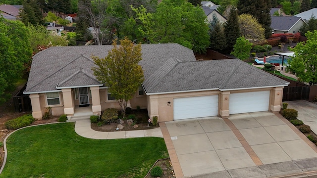 ranch-style house with an attached garage, driveway, and stucco siding