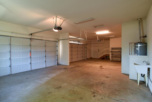 garage featuring water heater, a sink, and a garage door opener