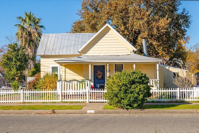 farmhouse with covered porch and a fenced front yard