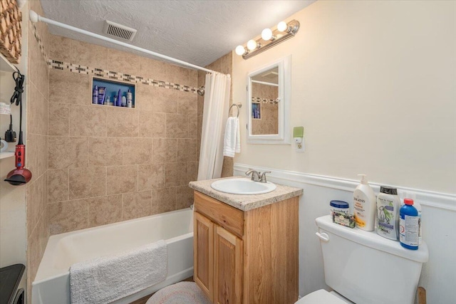 full bath with vanity, a wainscoted wall, toilet, shower / bathtub combination with curtain, and visible vents