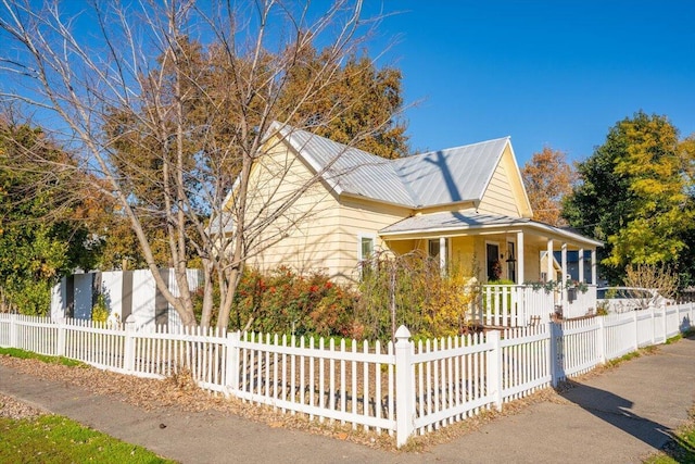 view of property exterior with a porch and a fenced front yard