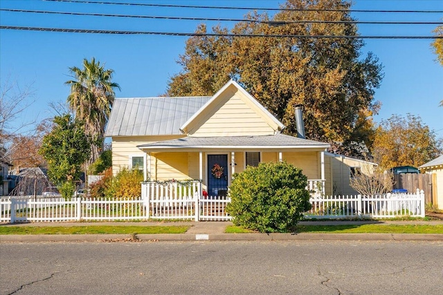 country-style home with covered porch and a fenced front yard