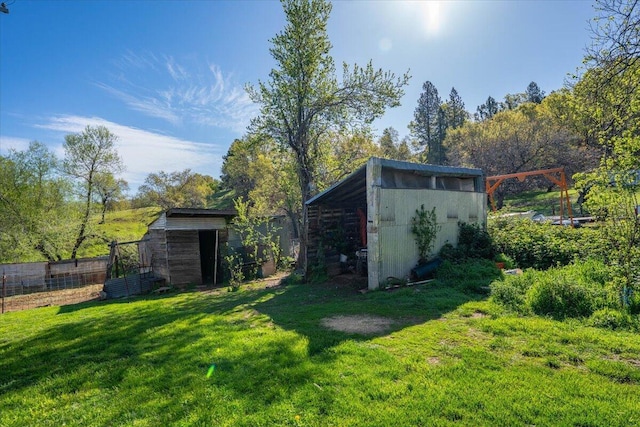 view of outdoor structure with fence and an outbuilding