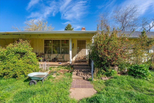 exterior space with a porch and a chimney