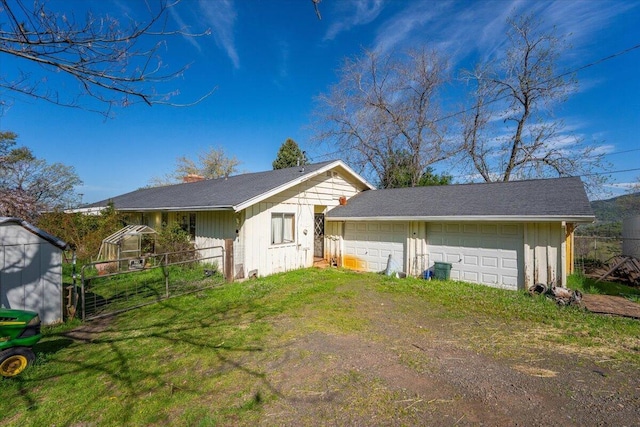 exterior space featuring a lawn, fence, and an outbuilding