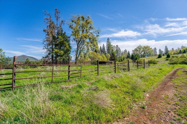 view of yard featuring fence and a rural view