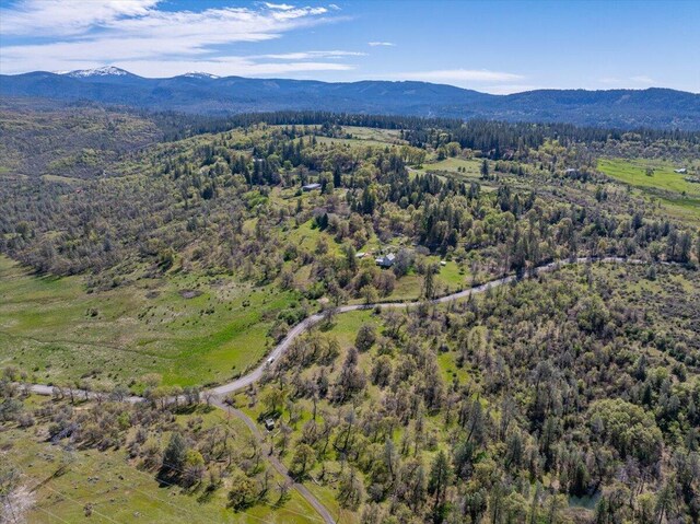 aerial view with a wooded view and a mountain view