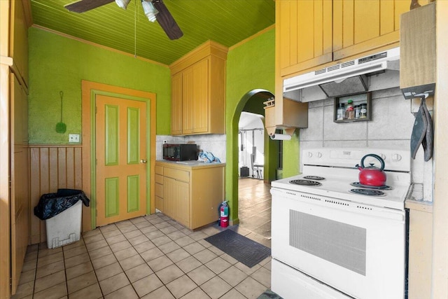 kitchen with black microwave, light tile patterned flooring, under cabinet range hood, arched walkways, and electric stove