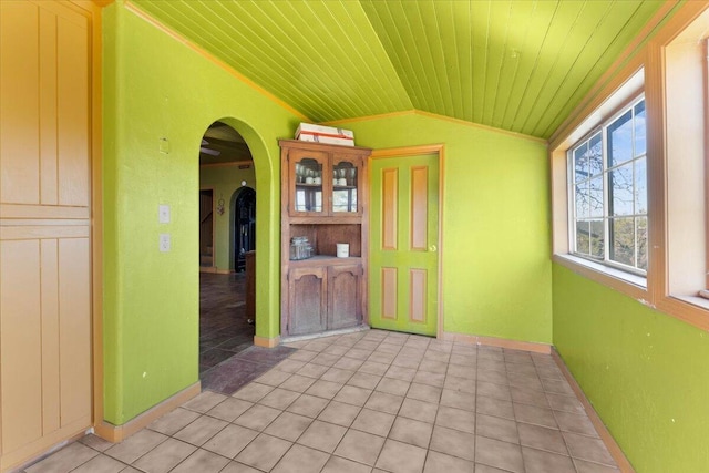 spare room with light tile patterned floors, arched walkways, wooden ceiling, lofted ceiling, and baseboards