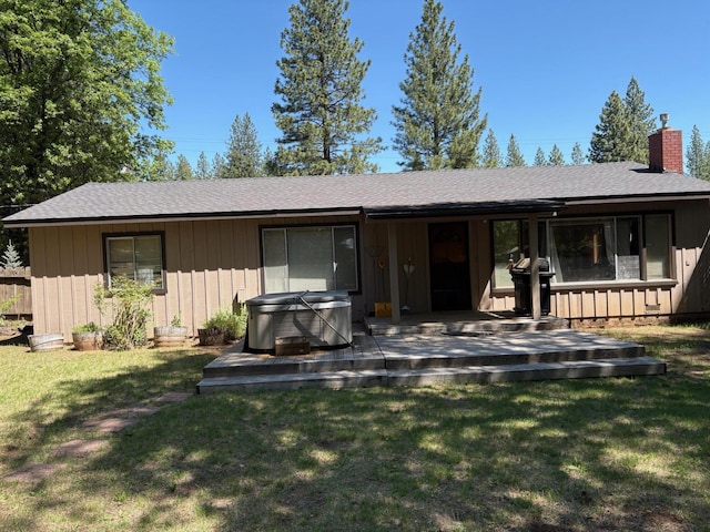 37061 Park Ave, Burney, CA 96013 - rear view of property featuring a hot tub, a chimney, a deck, a yard, and roof with shingles