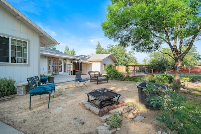 view of patio featuring an outdoor fire pit, a wooden deck, and fence