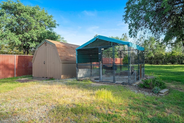view of outdoor structure featuring fence and an outbuilding