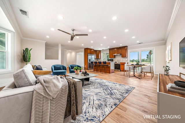 living area featuring light wood-type flooring, visible vents, ornamental molding, and recessed lighting