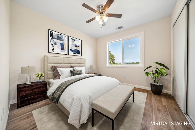 bedroom with a closet, light wood-type flooring, visible vents, baseboards, and ceiling fan