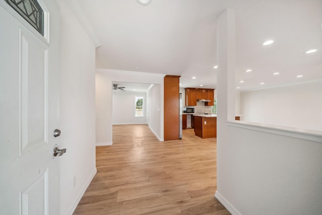 hallway featuring crown molding, light wood-type flooring, baseboards, and recessed lighting