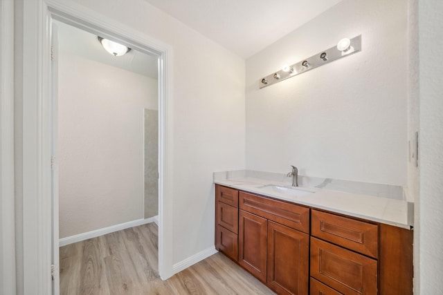 bathroom with vanity, baseboards, and wood finished floors