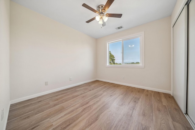 unfurnished bedroom featuring a closet, visible vents, a ceiling fan, baseboards, and light wood-style floors