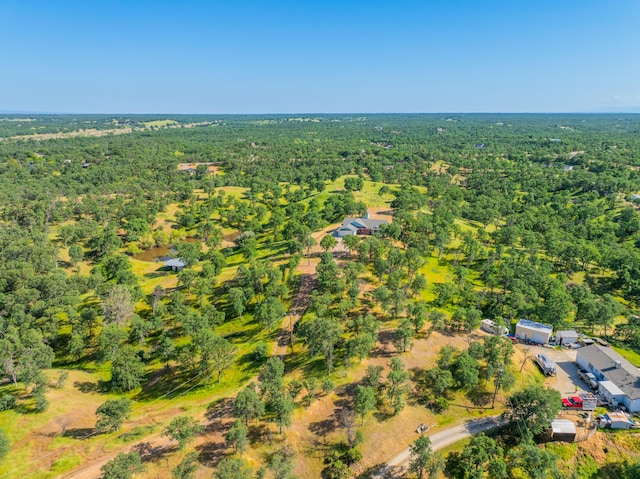 drone / aerial view featuring a wooded view