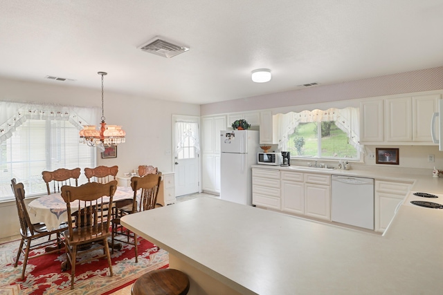 9400 Placer Rd, Redding, CA 96001 - kitchen with white appliances, a notable chandelier, a peninsula, and plenty of natural light
