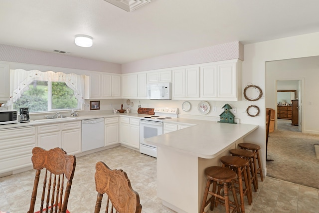 9400 Placer Rd, Redding, CA 96001 - kitchen featuring visible vents, a sink, a breakfast bar, white appliances, and a peninsula