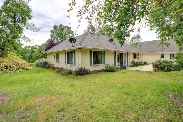9400 Placer Rd, Redding, CA 96001 - back of house featuring a patio area, roof with shingles, a lawn, and central air condition unit