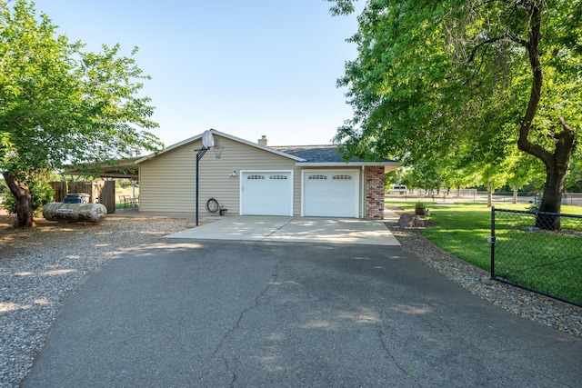 view of side of home with fence, brick siding, driveway, a yard, and a garage
