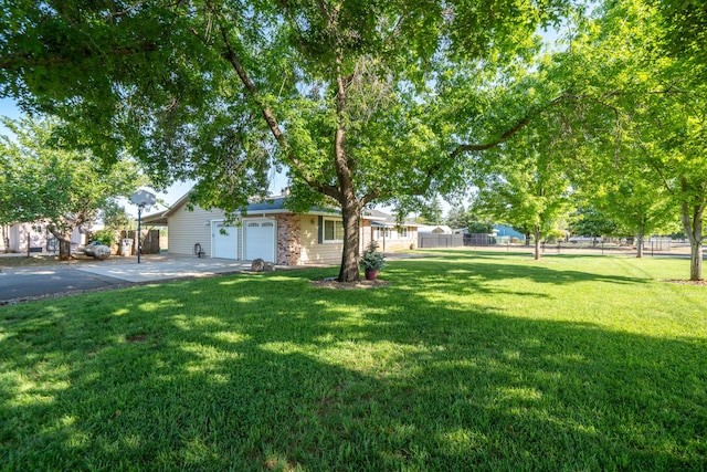 view of front of house featuring fence, a garage, driveway, and a front yard
