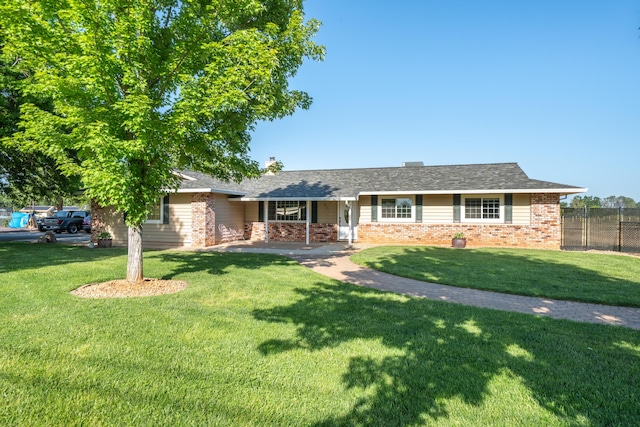 single story home with fence, brick siding, and a front yard
