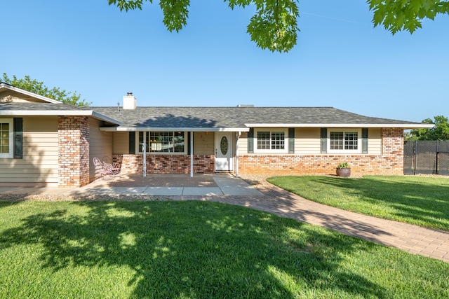 single story home with a front lawn, brick siding, a chimney, and fence